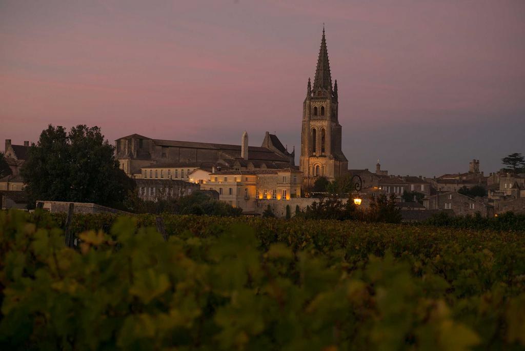 Saint-Émilion au crépuscule, le clocher éclairé au-dessus des vignes Saint-Émilion au crépuscule, le clocher éclairé au-dessus des vignes